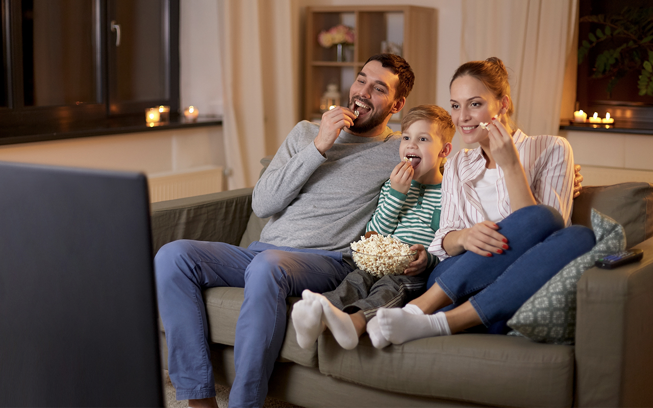 family sitting on a couch watching television
